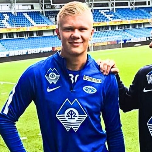 Erling Haaland wearing Molde FK blue and white jersey, posing with club logo visible on chest