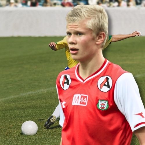 Erling Haaland wearing Bryne FK red and white jersey, posing with club logo visible on chest in the pitch