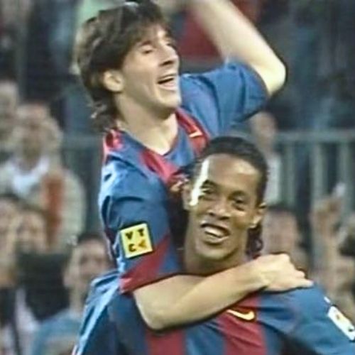 Lionel Messi with Ronaldinho at Barcelona after scoring his first goal, celebrating together with big smiles as Ronaldinho hugs Messi tightly after providing the assist, both wearing classic Barcelona jerseys at Camp Nou with cheering fans in the background.