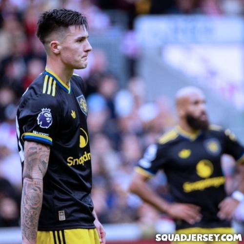 Brentford players dominating against Manchester United in their 3-1 victory and ManU players are looking sad in this photo, ManU players wear black yellow football jersey shirt away team maillot trikot for this match